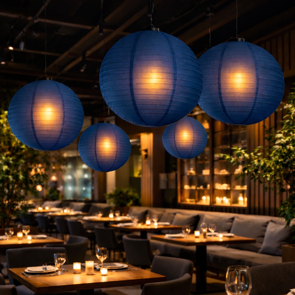 Indoor setting with blue paper lanterns, tables, and chairs in a restaurant or bar.