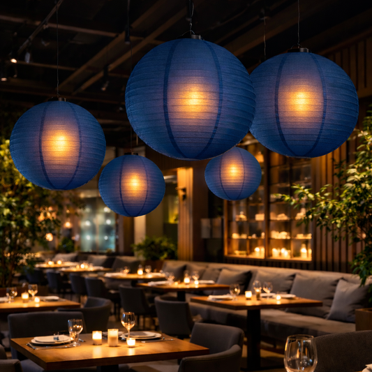 Indoor setting with blue paper lanterns, tables, and chairs in a restaurant or bar.