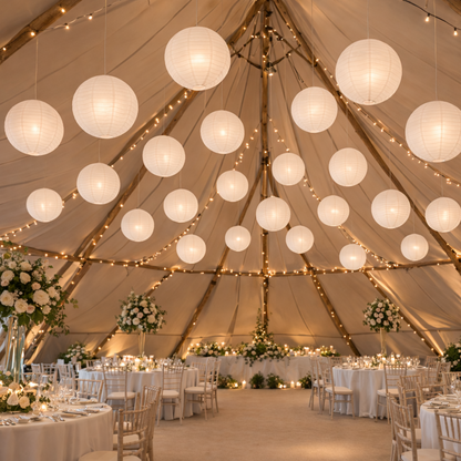 Decorative interior of a tent with hanging lights and floral arrangements.