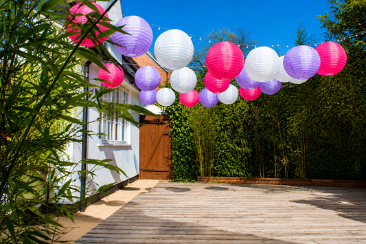 16-inch Lilac, Fuchsia and White nylon lanterns for a summer garden gathering. Hung across the space using fairy lights.